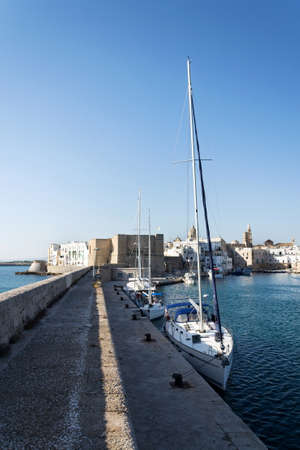 Beautiful boats in Monopoli port near Castle of Carlo V with church in background, Apulia, Bari province, Italyのeditorial素材