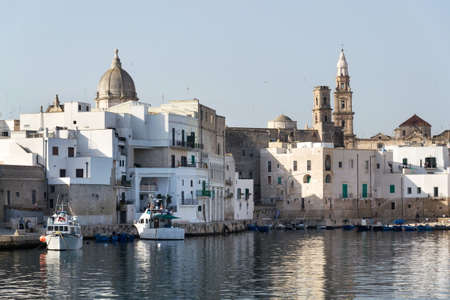 Beautiful boats in Monopoli port near Castle of Carlo V with church in background, Apulia, Bari province, Italyのeditorial素材