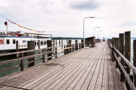INNING AM AMMERSEE, GERMANY - JULY 6 2019: Paddle Steamer Diessen floating by pier on the lake Ammersee on July 6, 2019 in Inning am Ammersee, Germany.のeditorial素材