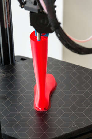 3d printer printing plastic last shoe prototype from red filamentの写真素材