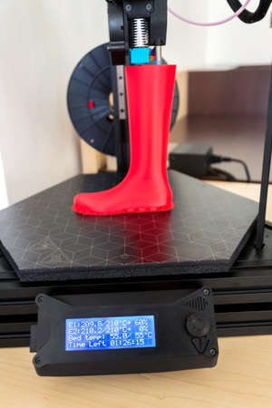3d printer printing plastic last shoe prototype from red filamentの写真素材