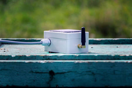White transmitter with small solar panel and bees monitoring system on green wooden beehive, smart technology iot applicationの写真素材