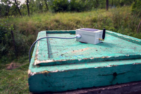 White transmitter with small solar panel and bees monitoring system on green wooden beehive, smart technology iot applicationの写真素材