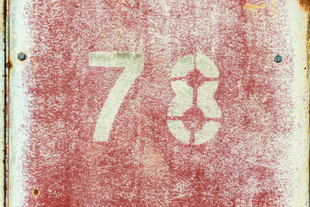 Number 78 on vintage rusty red and white metal sheet plateの写真素材