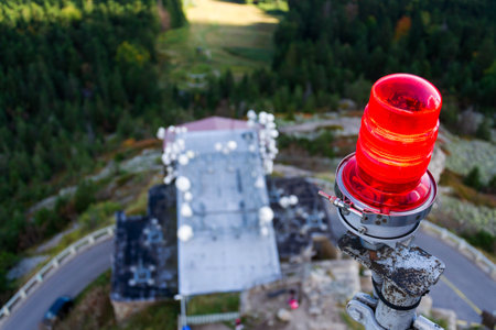 Red warning lights for air traffic on roof of high building, airport lighting equipment, daylightの写真素材