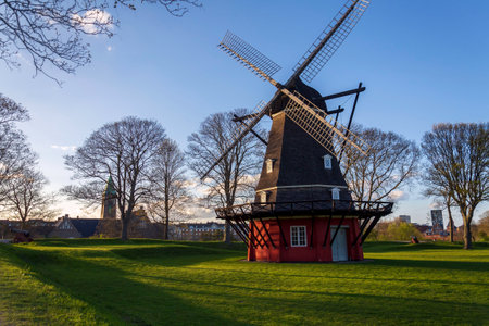 Windmill Kastellsmolen on island with fortress Kastellet citadel in Copenhagen, Denmark, sunset on...