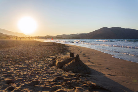 Beautiful sand castle on the beach at sunset, children's creativity, active vacation conceptの写真素材