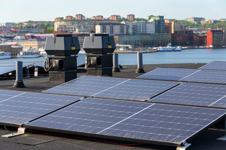 Solar panels on roof of apartment housing building with Gothenburg city center in background,...