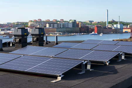 Solar panels on roof of apartment housing building with Gothenburg city center in background, Sweden, renewable green sustainable energy conceptの写真素材