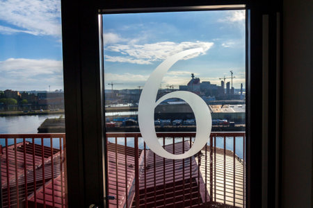 Number 6 on the glass door of an apartment building, sunny day