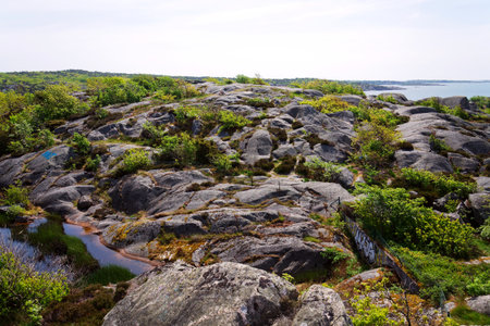 Rocks around public sea bath of Saltholmen peninsula on shore of Alvsborgsfjorden harbor, Alvsborg district, sunny day, Gothenburg, Swedenの写真素材