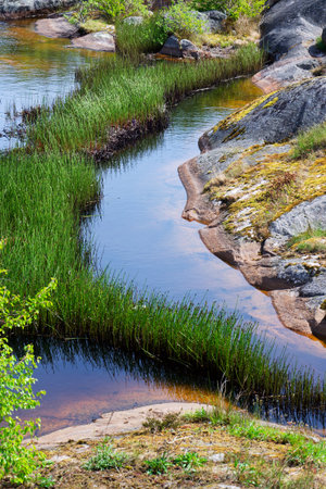 Rocks around public sea bath of Saltholmen peninsula on shore of Alvsborgsfjorden harbor, Alvsborg district, sunny day, Gothenburg, Swedenの写真素材