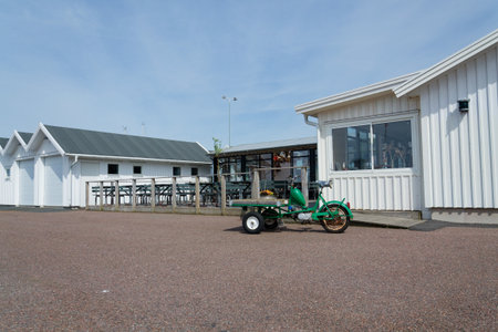 Flatbed moped parked on street of the peaceful car-free Vrango island with seaside village in Gothenburg archipelago, Vrango, Swedenの写真素材