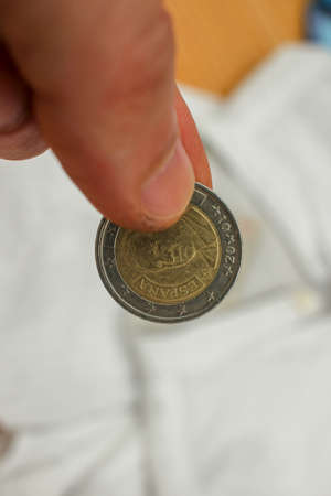euro coin between my fingers to pay for bread