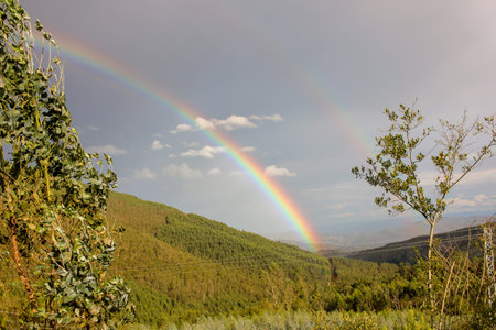 beautiful rainbow in the mountains of Vilacampa, Spain, in an autumn dayの写真素材