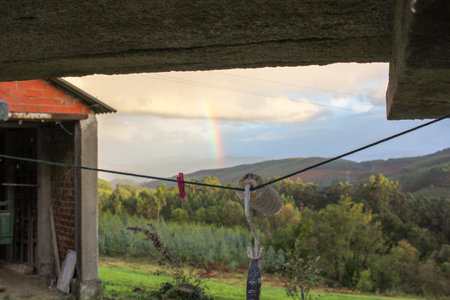 rainbow in the mountains from a houseの写真素材