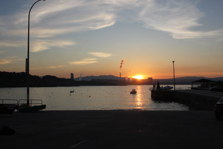 sunset lights in front of chimneys from an aluminum factory in the North of Spainの写真素材