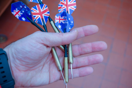 darts in a hand ready to play with them aiming at a bullseye