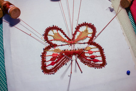 butterfly made by a senior woman at home with bobbin laceの写真素材