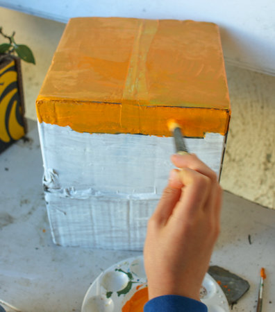 teenager recycling a cardboard box to make a house for a school projectの写真素材