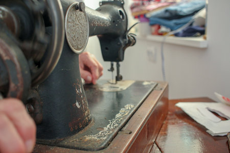 an elderly woman is working at home with her old sewing machine