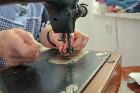 an elderly woman working with an antique sewing machine