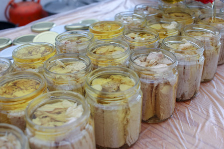 rows of bonito glass jars filled with olive oil to preserve itの写真素材