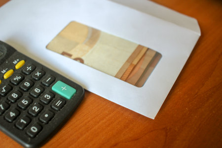 Counting Euro Cash with Office Calculator on a tableの写真素材