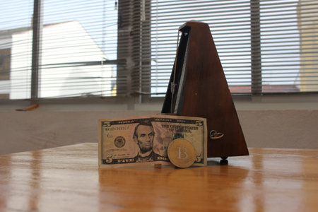 Metronome Keeping Time Beside a Five Dollar Billの写真素材