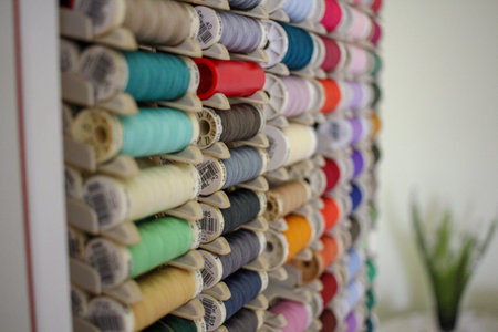 A full spectrum of colored thread bobbins creating a rainbow effect. Useful for concepts of variety,...