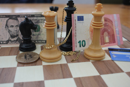 bank notes, fiat money, bitcoin and gold compete for a place in the chess board of the investor