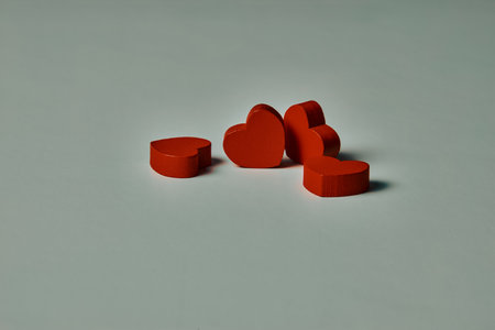 four wooden figures in the shape of red hearts two lyingの写真素材