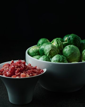two white bowls with ham and green brussels sprouts to make a healthy Mediterranean mealの写真素材