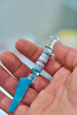 close view of a hand with a vaccine syringe
