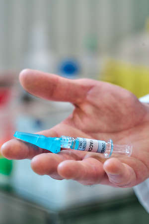 close view of a hand with a vaccine syringeの写真素材