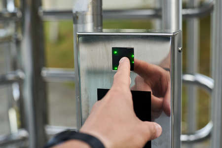 Hand pressing a fingerprint reader to open a security door. High quality photoの写真素材