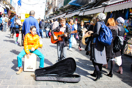 closeup of a street musician sing and play guitar at the entrance of Mahane Yehuda market in Jerusalem Israel February 16-2018 on the morningのeditorial素材