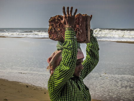 Unknowns women workers carrying stone on the head in Gokarna beach Karnataka India December 03-2017 on the morningのeditorial素材