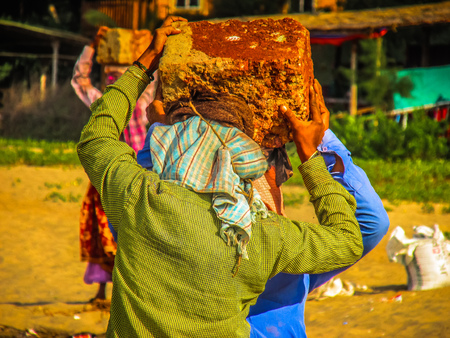Unknowns women workers carrying stone on the head in Gokarna beach Karnataka India December 03-2017 on the morningのeditorial素材