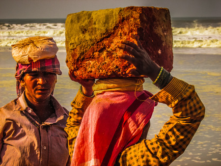 Unknowns women workers carrying stone on the head in Gokarna beach Karnataka India December 03-2017 on the morningのeditorial素材