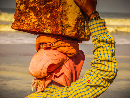 Unknowns women workers carrying stone on the head in Gokarna beach Karnataka India December 03-2017 on the morningのeditorial素材