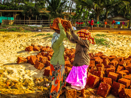 Unknowns women workers carrying stone on the head in Gokarna beach Karnataka India December 03-2017 on the morningのeditorial素材