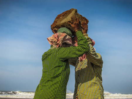 Unknowns women workers carrying stone on the head in Gokarna beach Karnataka India December 03-2017 on the morningのeditorial素材