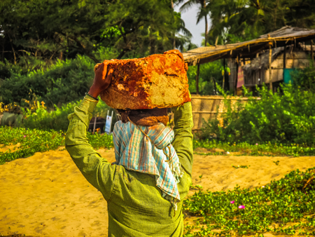 Unknowns women workers carrying stone on the head in Gokarna beach Karnataka India December 03-2017 on the morningのeditorial素材