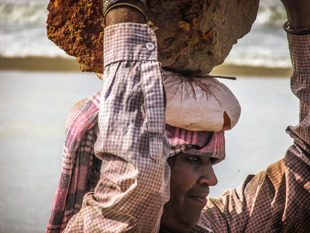 Unknowns women workers carrying stone on the head in Gokarna beach Karnataka India December 03-2017 on the morningのeditorial素材