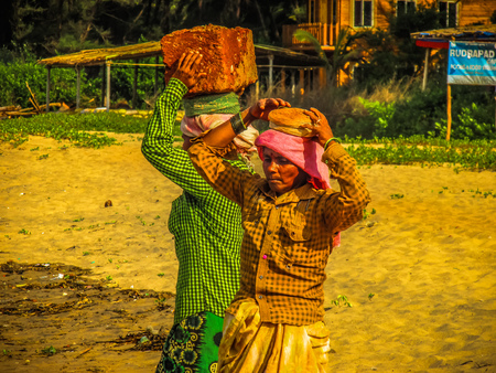 Unknowns women workers carrying stone on the head in Gokarna beach Karnataka India December 03-2017 on the morningのeditorial素材
