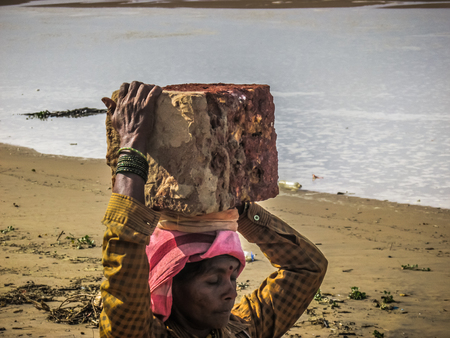 Unknowns women workers carrying stone on the head in Gokarna beach Karnataka India December 03-2017 on the morningのeditorial素材