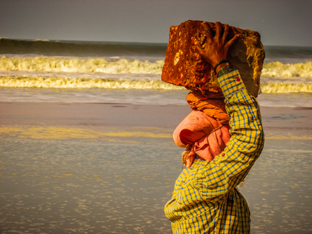 Unknowns women workers carrying stone on the head in Gokarna beach Karnataka India December 03-2017 on the morningのeditorial素材