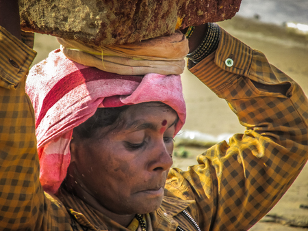 Unknowns women workers carrying stone on the head in Gokarna beach Karnataka India December 03-2017 on the morningのeditorial素材