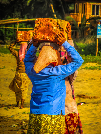 Unknowns women workers carrying stone on the head in Gokarna beach Karnataka India December 03-2017 on the morningのeditorial素材